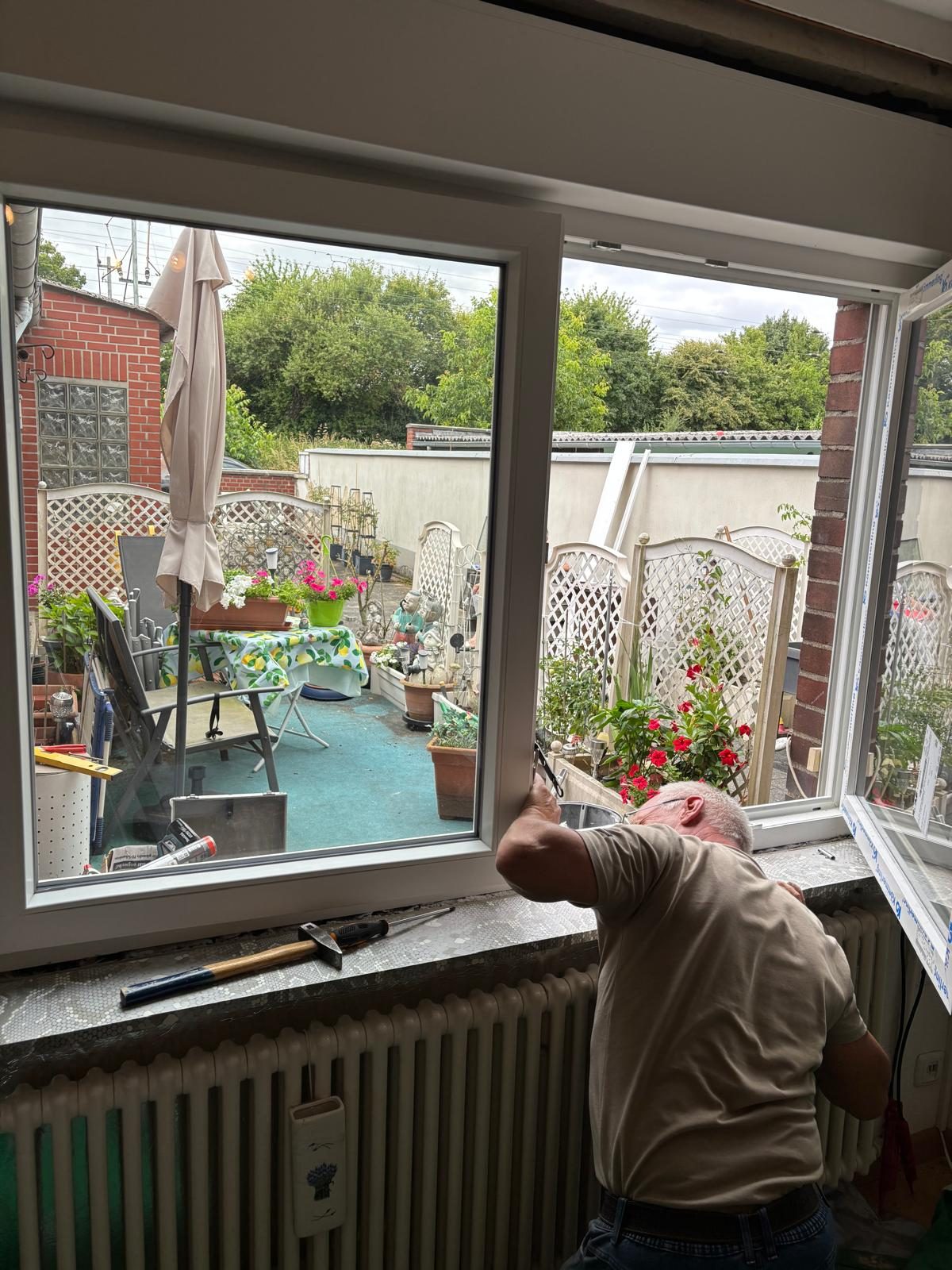 Monteur setzt einen neuen Fensterflügel von innen ein